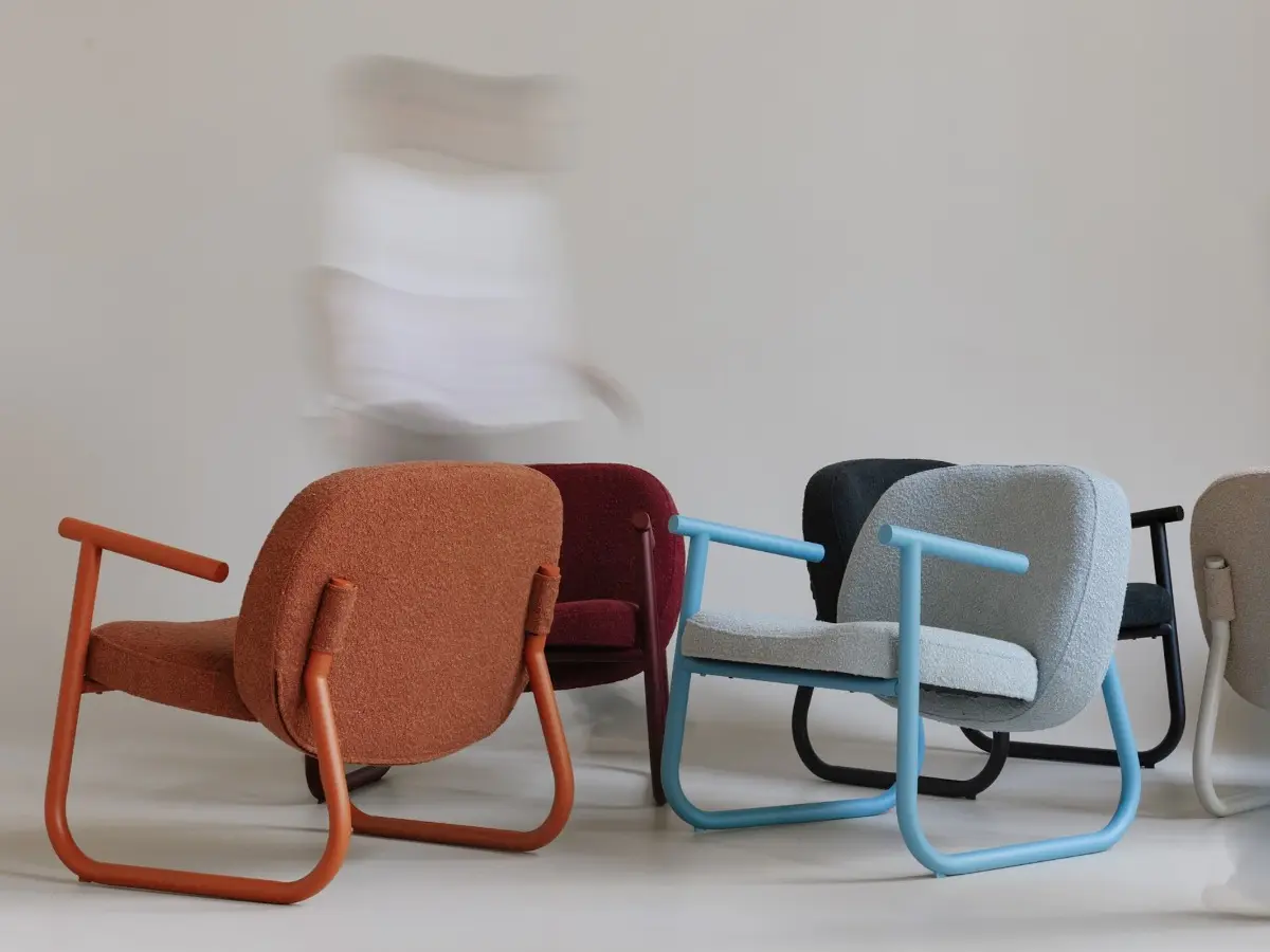 The rounded shapes of the back and seat create a unique silhouette of the object, as if levitating between two metal supports.