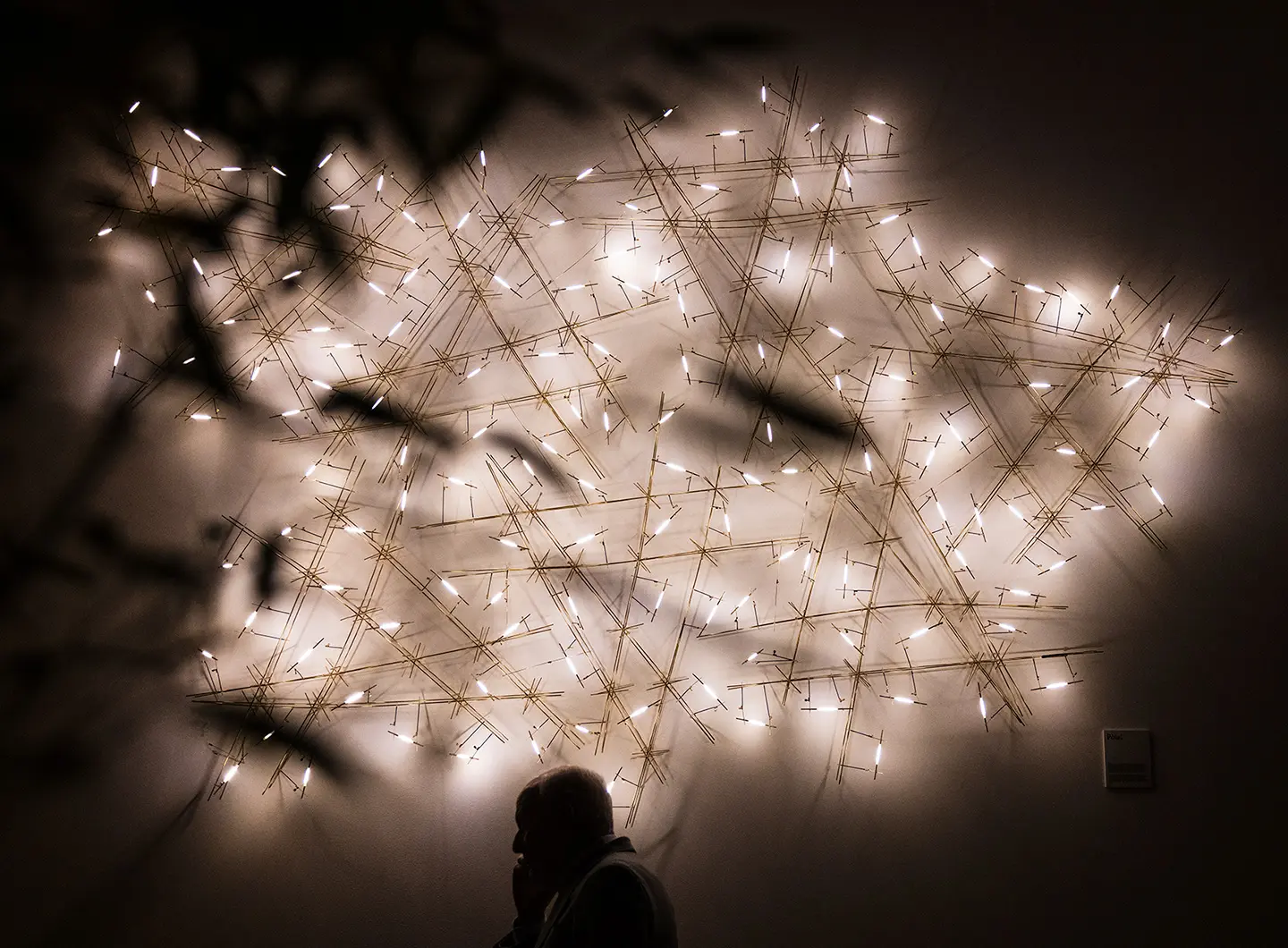 corpo illuminante con sottili strutture in ottone che creano un disegno