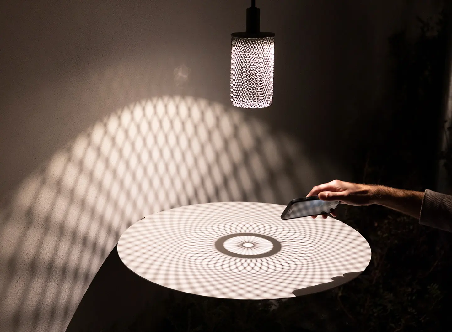 lampada da esterno con struttura forata in acciaio che crea pattern