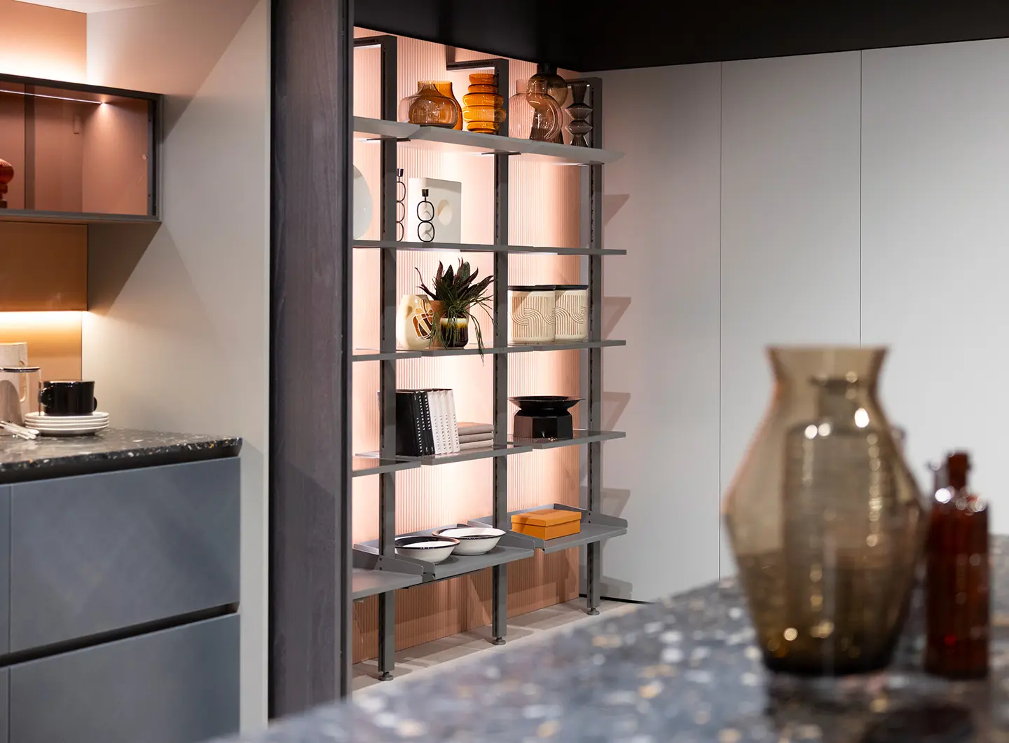 Mobile da cucina con piano in marmo grigio scuro e cassetti grigi, ripiano dispensa grigio con anta a ribalta