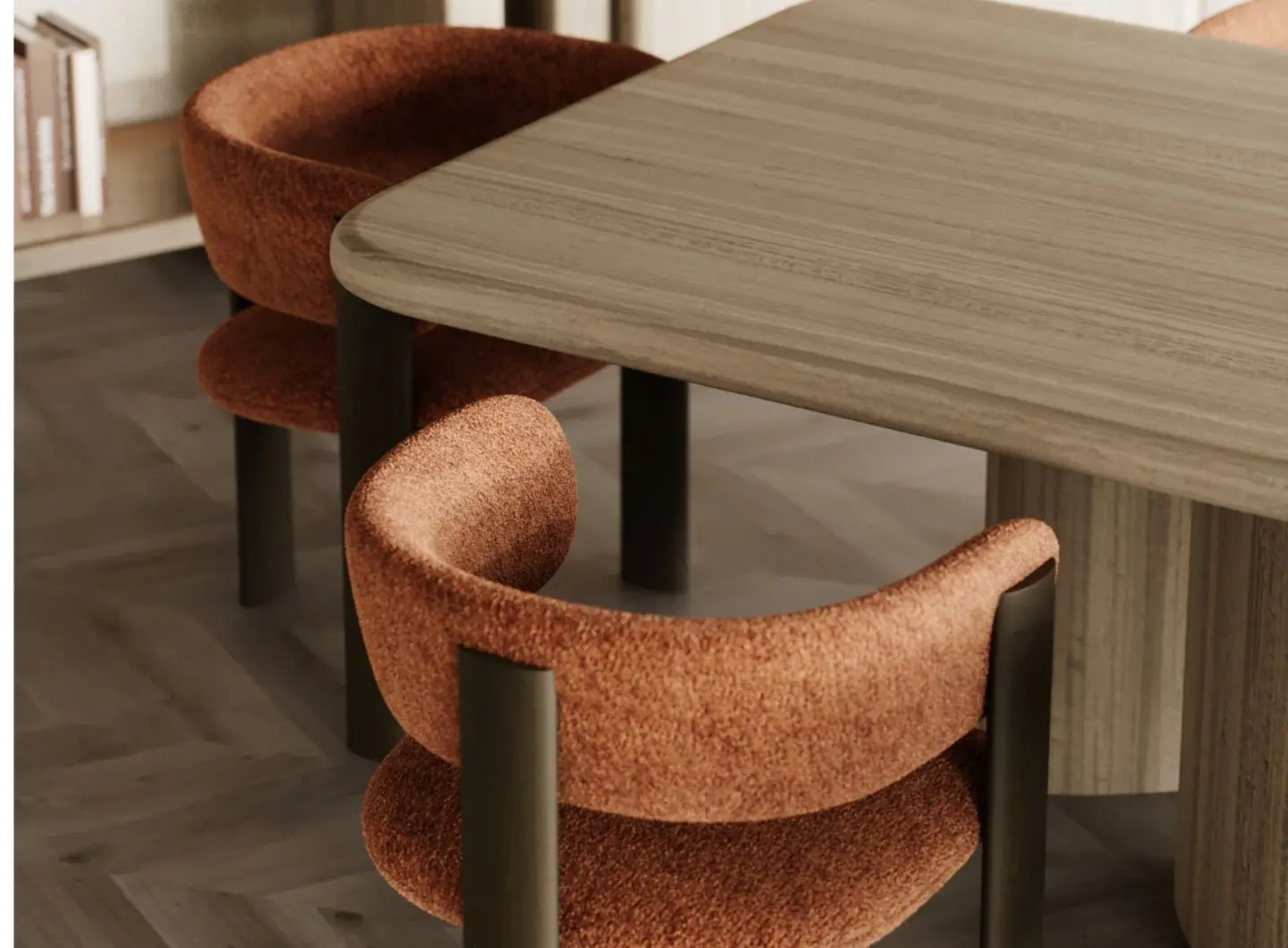 La sedia Dolomites è raffigurata in un ambiente da pranzo come una sedia imbottita color ruggine con schienale ricurvo e seduta imbottita, sostenuta da gambe cilindriche scure, collocata accanto a un tavolo in legno chiaro con dei libri sulla mensola alle sue spalle.