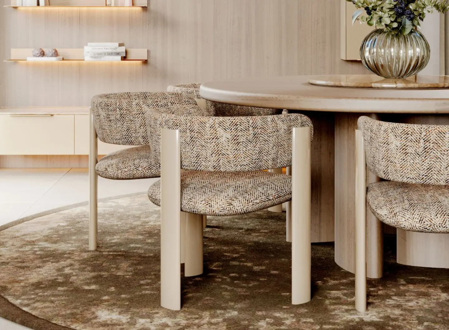 Il Tavolo da pranzo Rotondo Dolomites appare in una sala da pranzo minimalista con sedie imbottite dalle gambe cilindriche, posizionato su un tappeto dai toni naturali. Un vaso in vetro con fiori decora il centro del tavolo, mentre mensole in legno e illuminazione calda completano un’atmosfera calma e armoniosa.