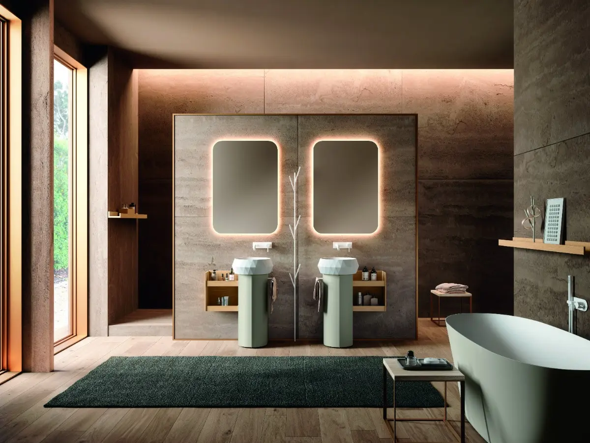 Calix UP. Elemento a terra con anta tonda in laccato peltro opaco. Pensile a giorno in HPL rovere Valdweg. Lavabo da appoggio Diamond in teknorit bianco. Specchio Rondo con LED perimetrale. Vasca Salus in solid surface. Attaccapanni ad albero in laccato bianco opaco.