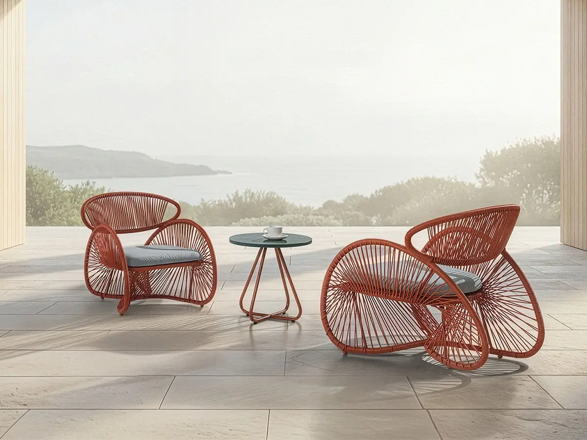 The AERO Easy Armchair, AERO Easy Chair and AERO End Table overlook the sea against a tranquil morning.