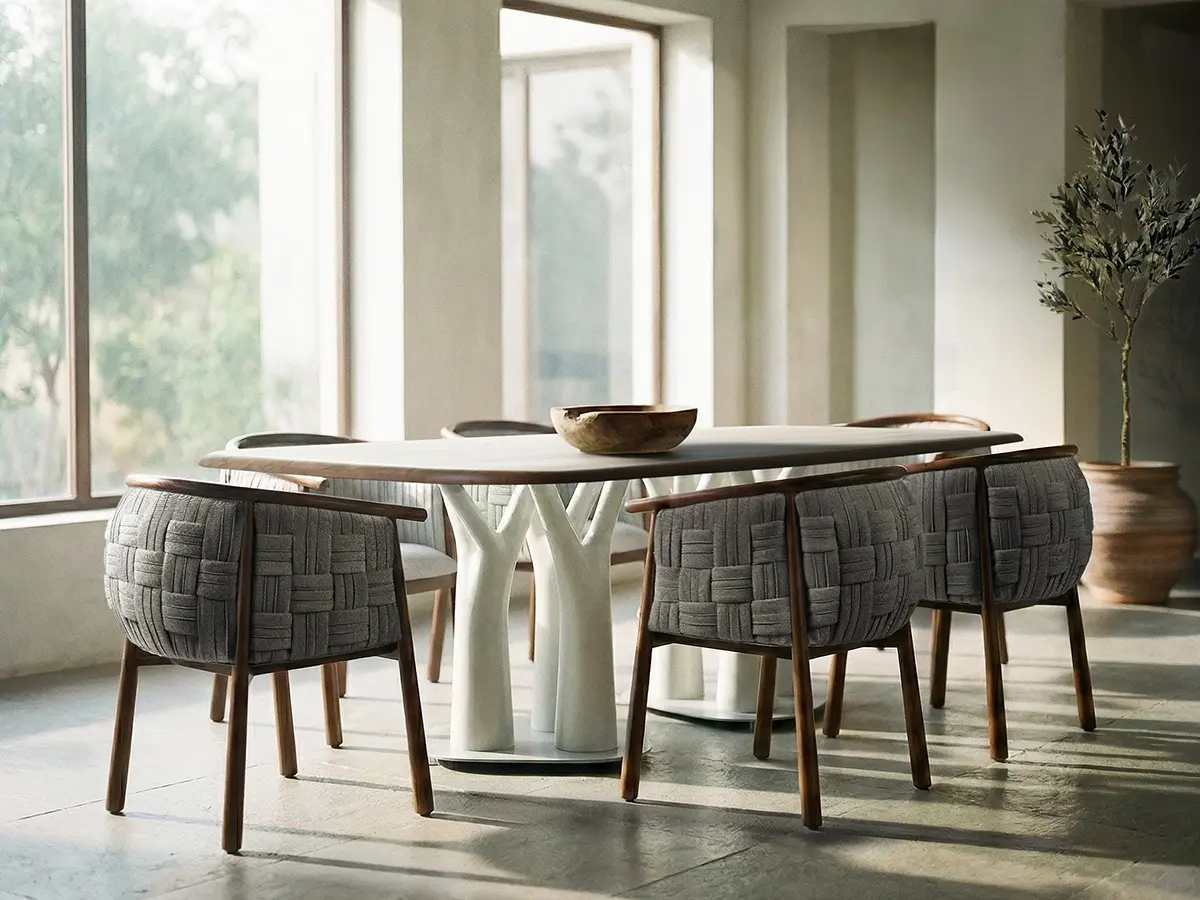 A collection of BASKET Chairs are arranged around the LAGUNA Dining Table. The scene prominently features the plush Panama weave of the BASKET Chairs' backsides.
