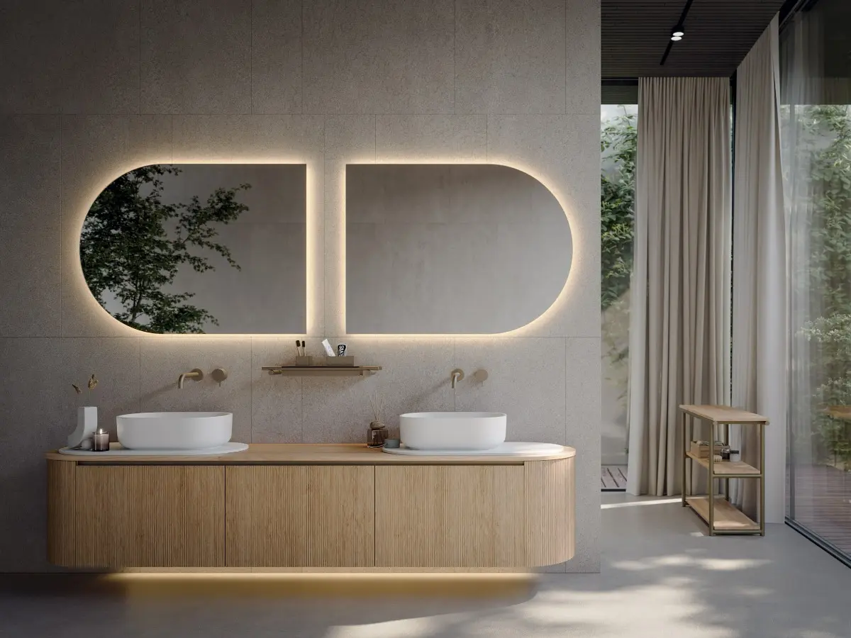 Bagno Elle. Basi con anta “Elle” e top in legno Rovere Naturale, maniglia in alluminio finitura in titanio. Base curva finale con cassetto estraibile o con anta e ripiano. Lavabo Oblon e vassoio in Teknorit bianco opaco. Specchio retroilluminato.