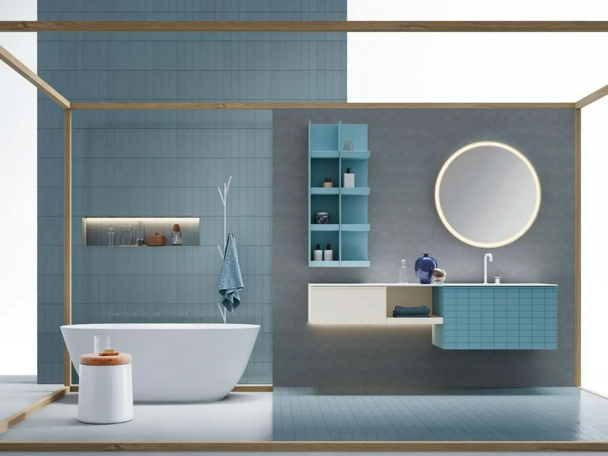 Bagno Bloom. Base portalavabo con anta Tile e maniglia Zig laccata turchese opaco, base a giorno e base laterale con anta liscia laccata platino opaco. Piano lavabo in Teknorit bianco opaco. Specchio tondo Bloom con telaio in metallo curvato laccato bianco opaco con LED perimetrali. Pensile a giorno laccato turchese opaco.