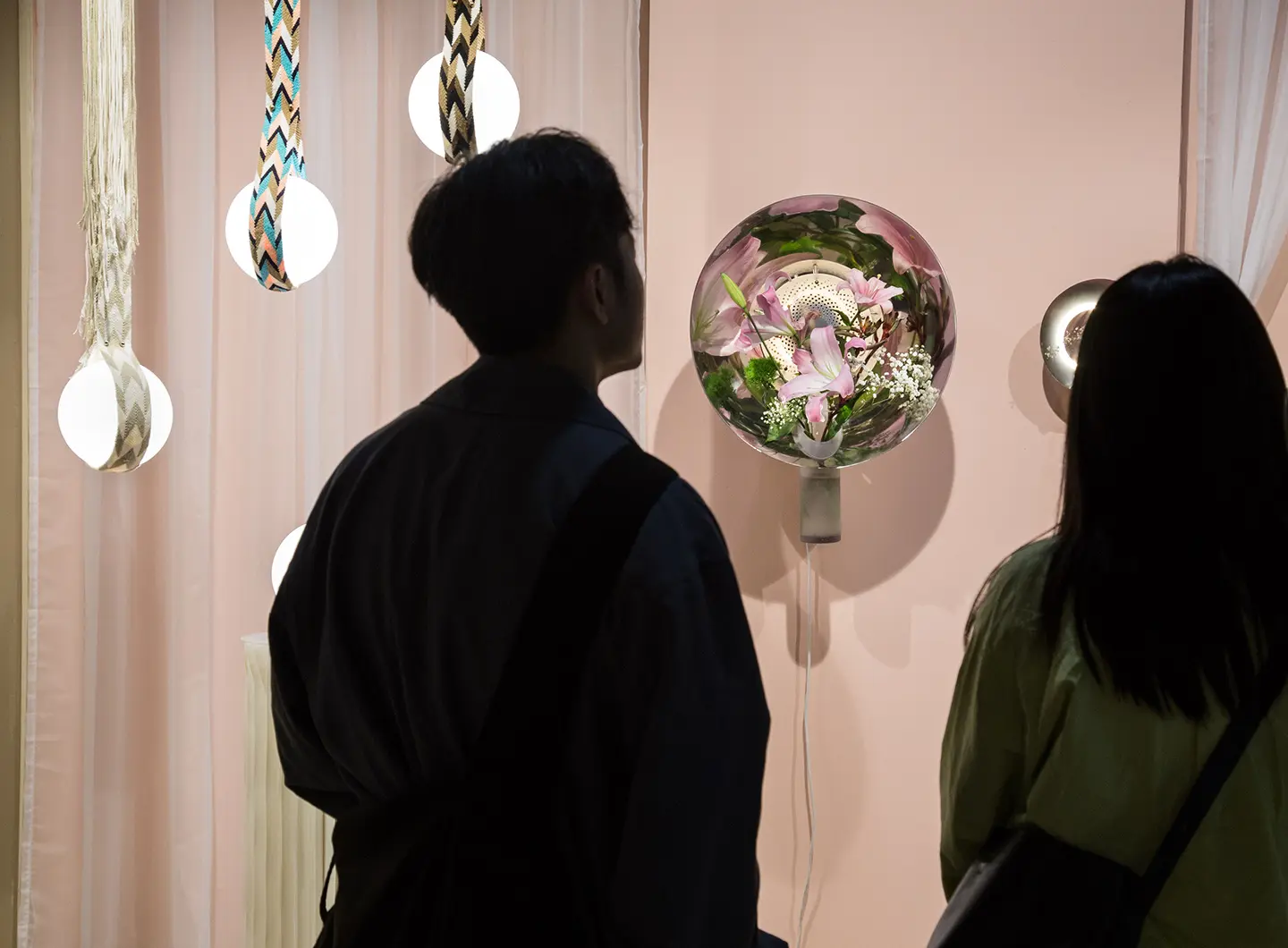 Visitors looking at glass lamps with flowers